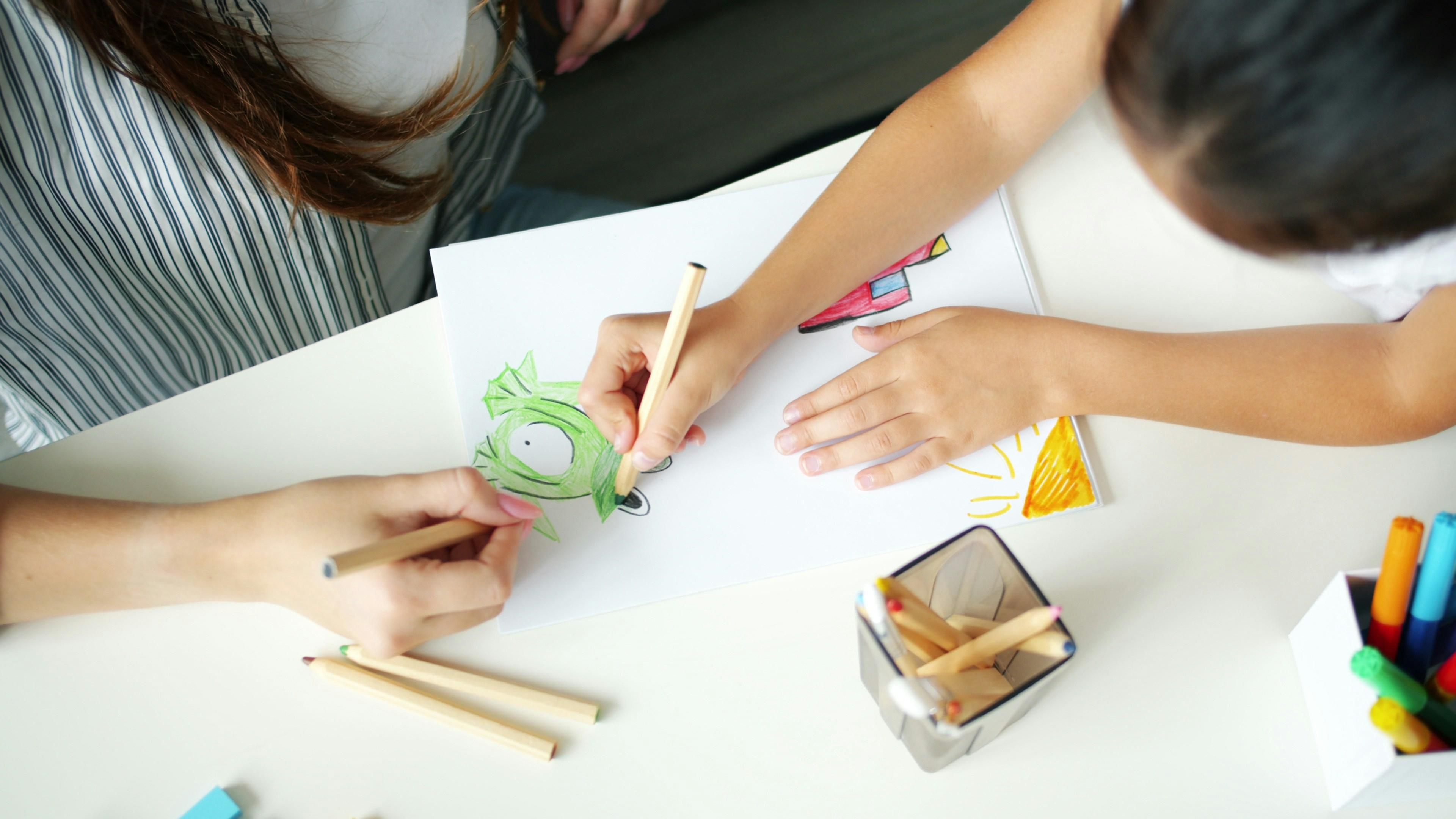Parent and child drawing together at home